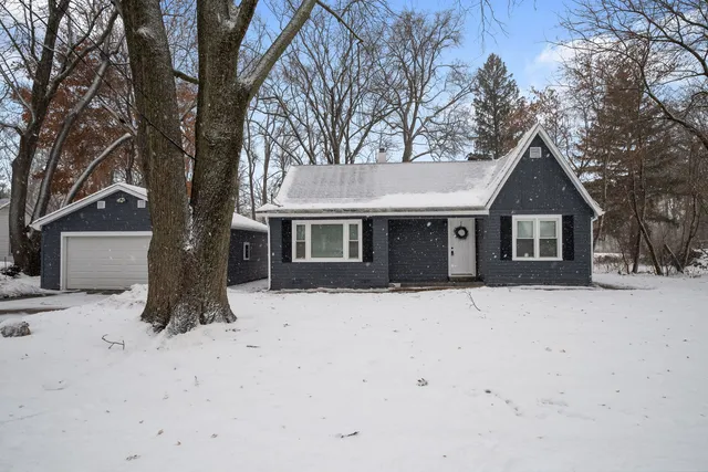 a front view of a house with a yard covered in snow