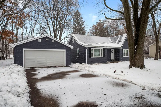 a front view of a house with a yard covered in snow