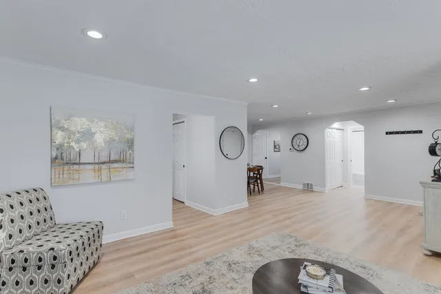 a view of a livingroom with wooden floor and furniture