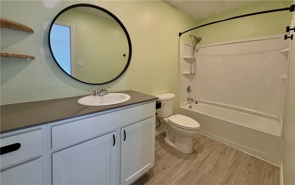 1109 Demeter Drive Portland, TX 78374 - Photo 11 of 18 a bathroom with a granite countertop toilet sink and mirror