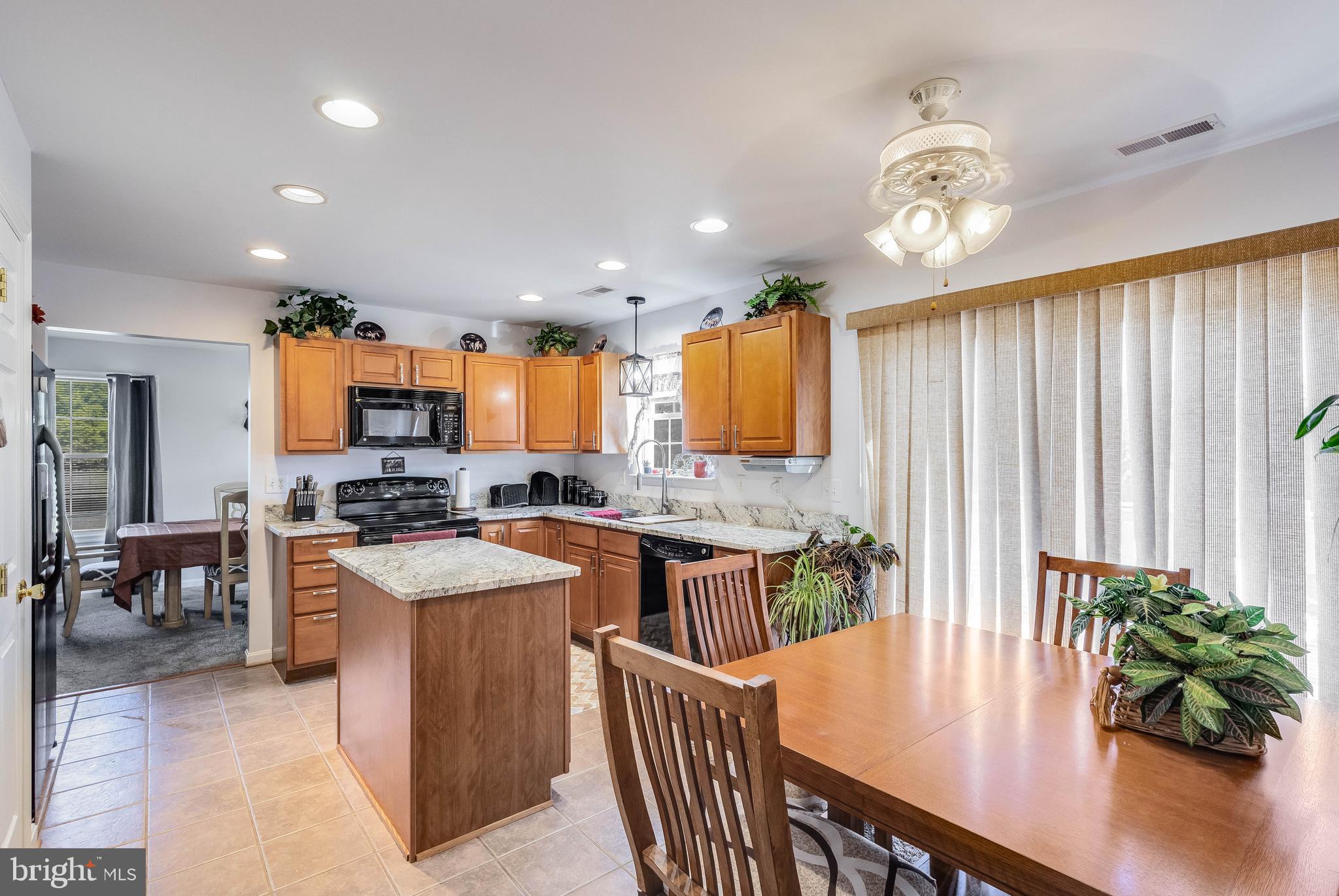 4757 Long Swamp Road Federalsburg, MD 21632 - Photo 9 of 47 a kitchen with stainless steel appliances kitchen island granite countertop a stove a sink a refrigerator and a dining table