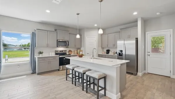 a kitchen with a center island appliances and cabinets