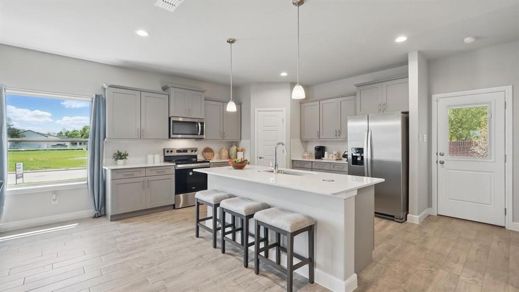 a kitchen with a center island appliances and cabinets