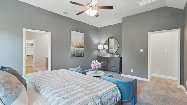 a bedroom with a bed chandelier and a mirror