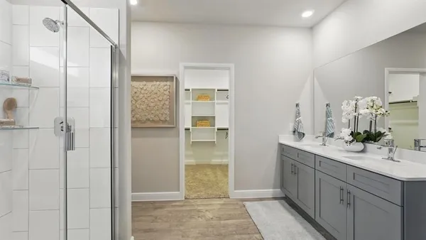a bathroom with a double vanity sink a mirror and a shower