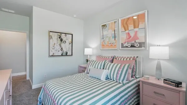 a bedroom with a bed and painting on the wall