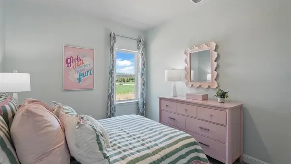 a bedroom with a bed and a dresser in it