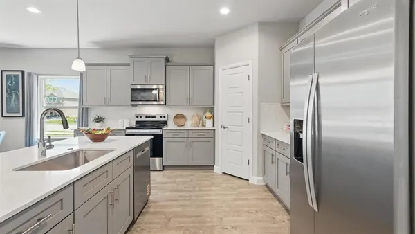 a kitchen with a sink refrigerator and cabinets