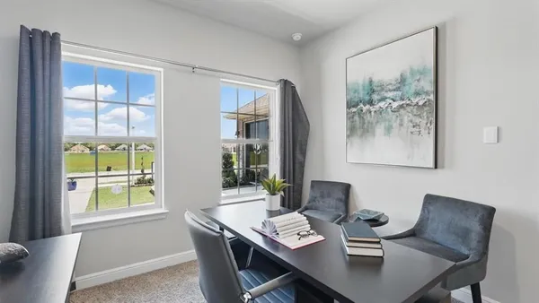a view of a workspace with furniture and a window