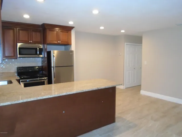 a kitchen with stainless steel appliances a refrigerator and a stove