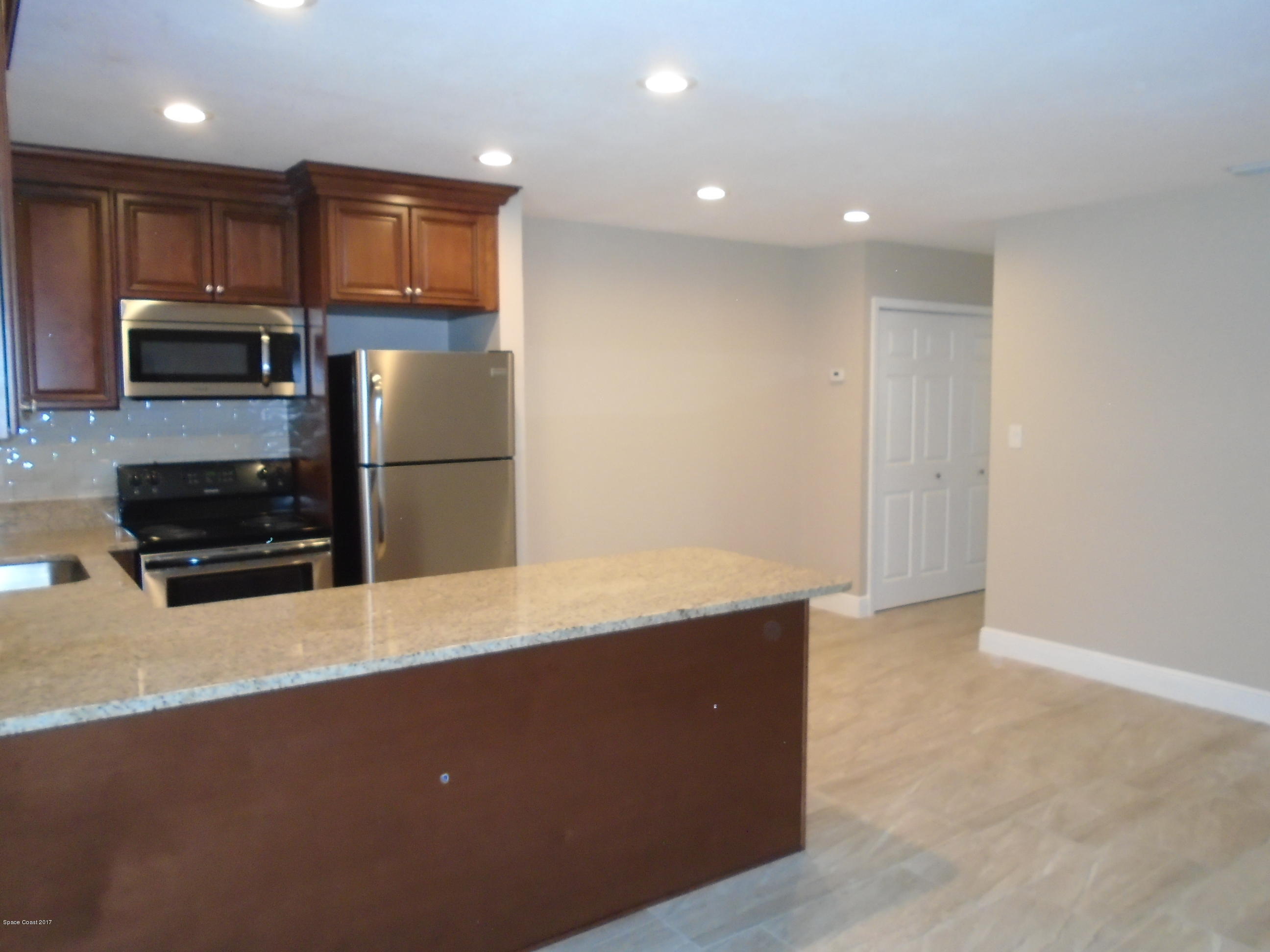 5600 North Banana River Boulevard, Unit 46 Cocoa Beach, FL 32931 - Photo 2 of 13 a kitchen with stainless steel appliances a refrigerator and a stove