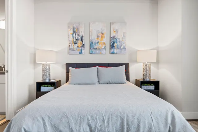 a bedroom with a bed and a painting on the wall