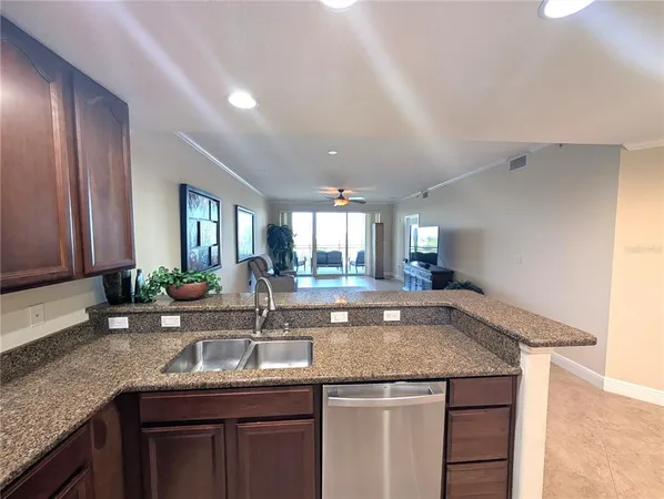 a kitchen with granite countertop kitchen island a sink a counter space and stainless steel appliances