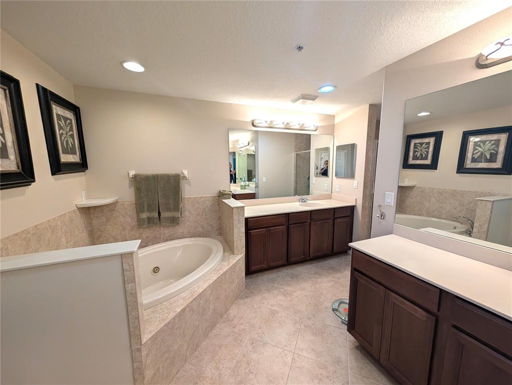7070 Key Haven Road, Unit 602 Seminole, FL 33777 - Photo 37 of 48 a bathroom with a double vanity sink a mirror a bathtub and a toilet