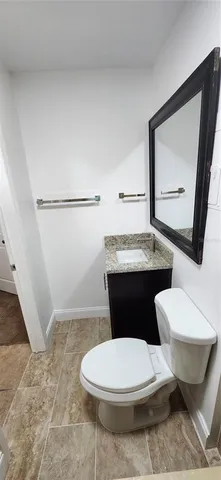 a bathroom with a toilet a sink and mirror
