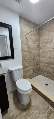 a bathroom with a toilet and a shower