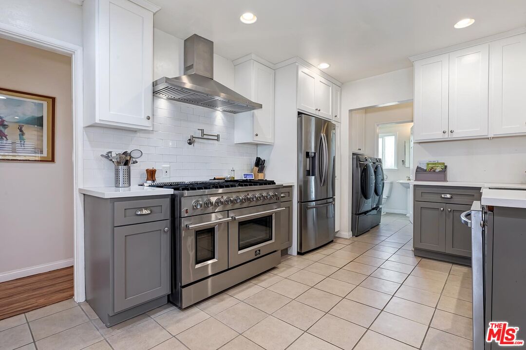 a kitchen with stainless steel appliances granite countertop a stove a refrigerator and a cabinets