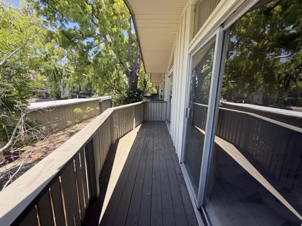 a view of balcony with wooden floor and fence