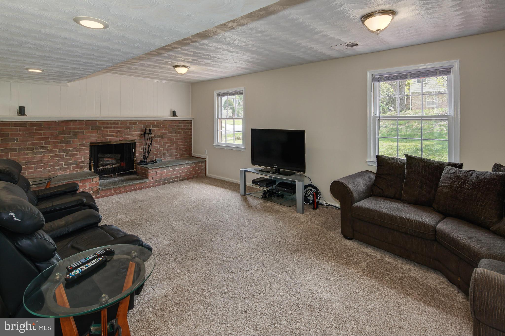1530 Arbor View Road Silver Spring, MD 20902 - Photo 24 of 30 a living room with furniture a fireplace and a flat screen tv