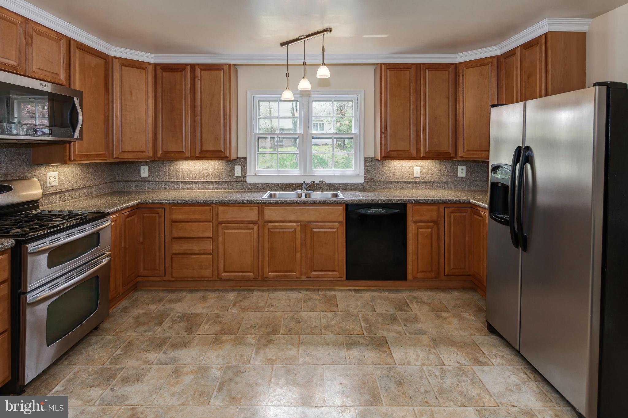 1530 Arbor View Road Silver Spring, MD 20902 - Photo 8 of 30 a kitchen with stainless steel appliances granite countertop a stove top oven a refrigerator and a sink