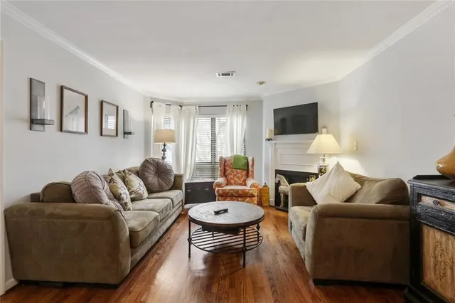 a living room with furniture a fireplace a flat screen tv and a large window