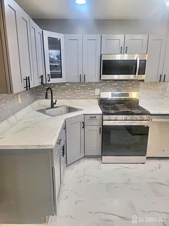 a kitchen with a sink stove and microwave