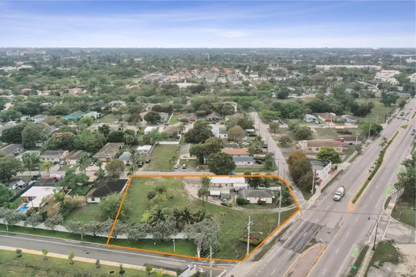 an aerial view of residential houses with outdoor space and trees