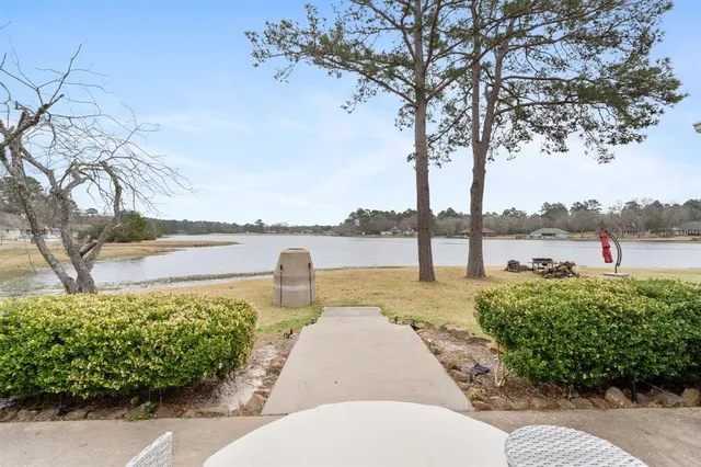 a view of a lake with a big yard and potted plants