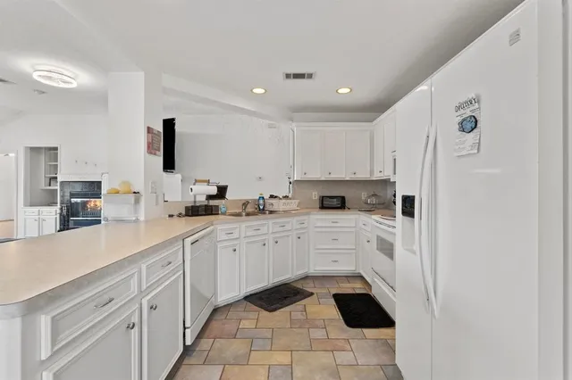 a kitchen with white cabinets a sink and white appliances