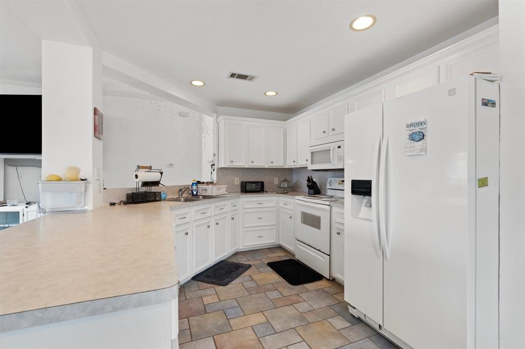 467 Pinnacle Trinity, TX 75862 - Photo 21 of 40 a kitchen with white cabinets and white appliances