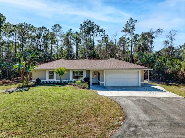 a view of a house with pool and chairs under an umbrella