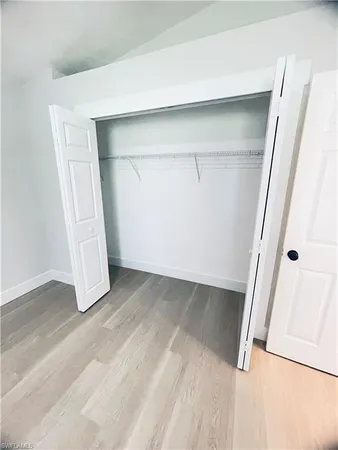 an empty room with a window and a ceiling fan