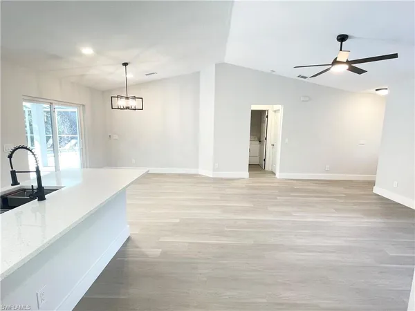a view of a kitchen with a sink wooden floor and a refrigerator