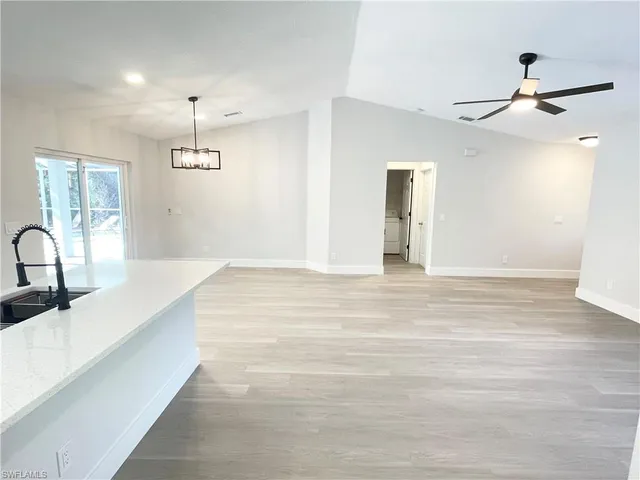 a view of a kitchen with a sink wooden floor and a refrigerator