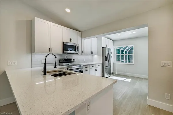 a view of a kitchen with a sink hardwood floor and a ceiling fan