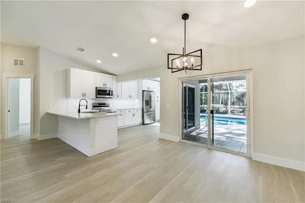 a kitchen with sink a microwave and refrigerator