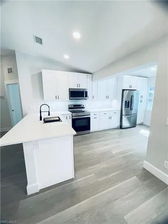 a view of kitchen with stainless steel appliances granite countertop cabinets and wooden floor