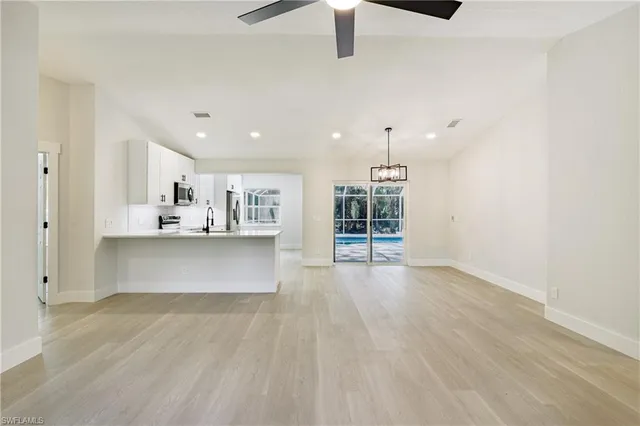 a kitchen with stainless steel appliances a refrigerator sink and wooden floor
