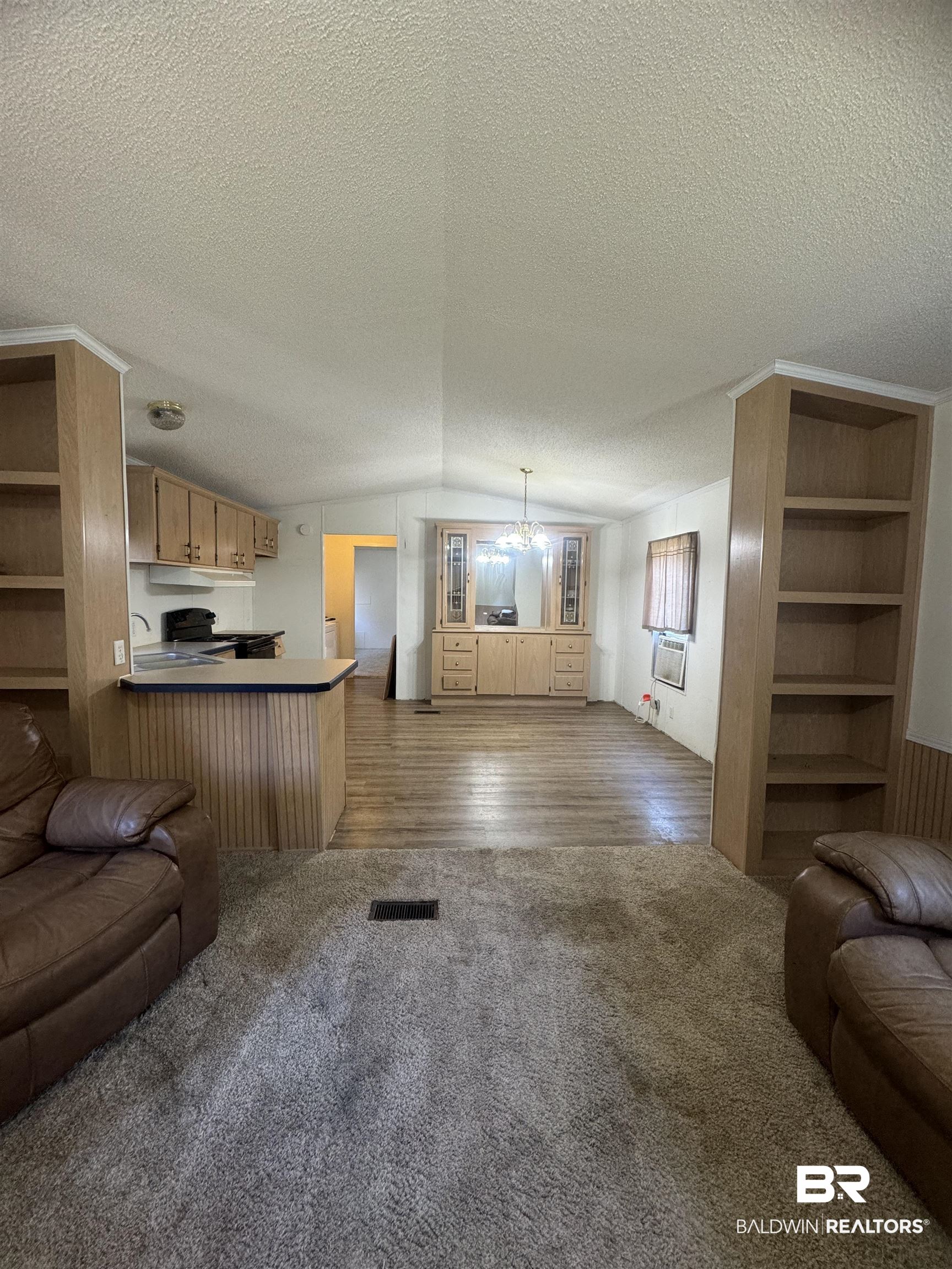 1067 County Road 7 Range, AL 36473 - Photo 3 of 30 Living room with a textured ceiling, wood-type flooring, vaulted ceiling, and a chandelier