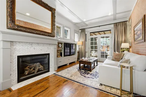 a living room with furniture a fireplace and a large window