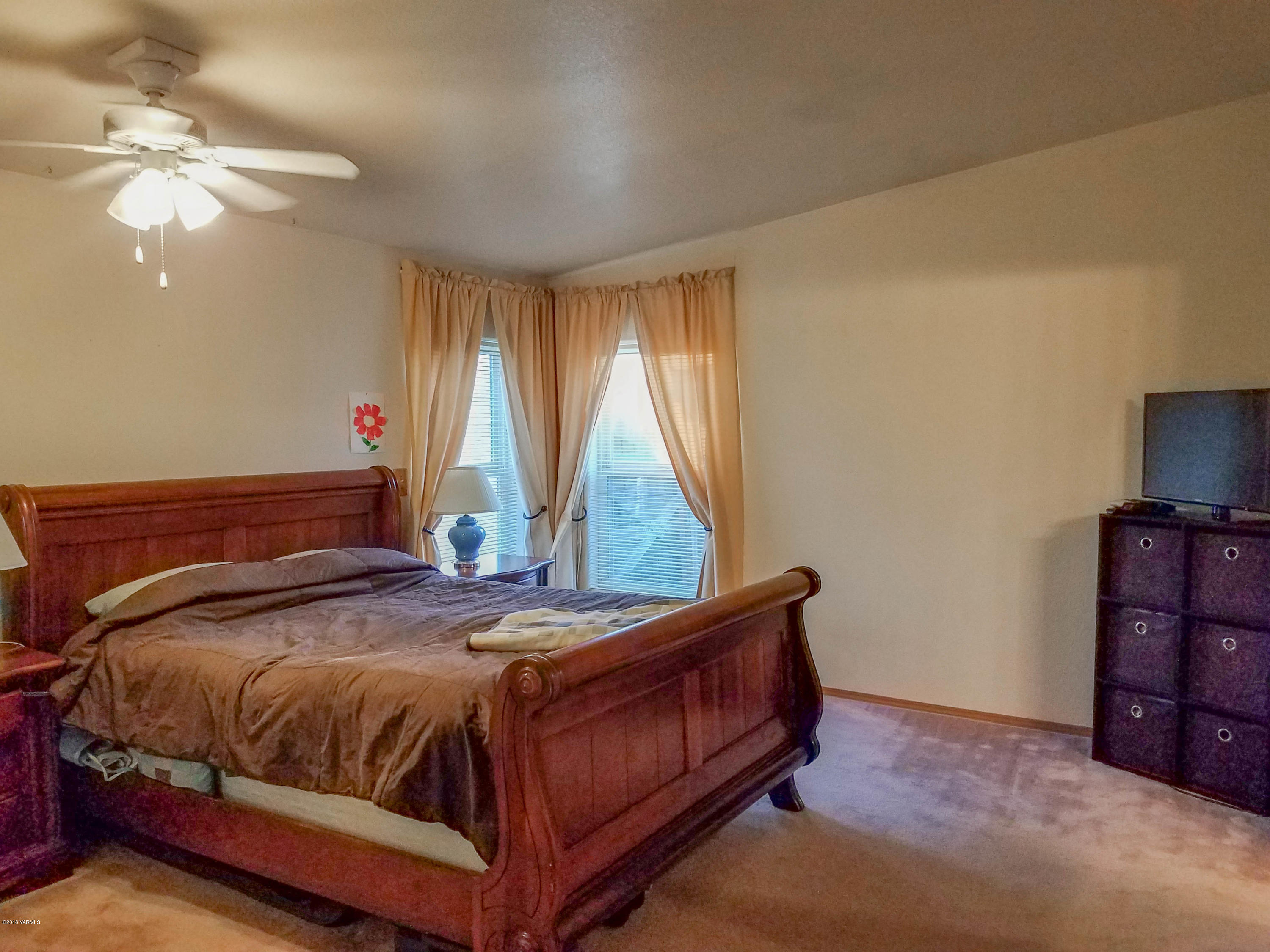 14811 Douglas Road Yakima, WA 98908 - Photo 10 of 18 a bedroom with a bed and a chandelier