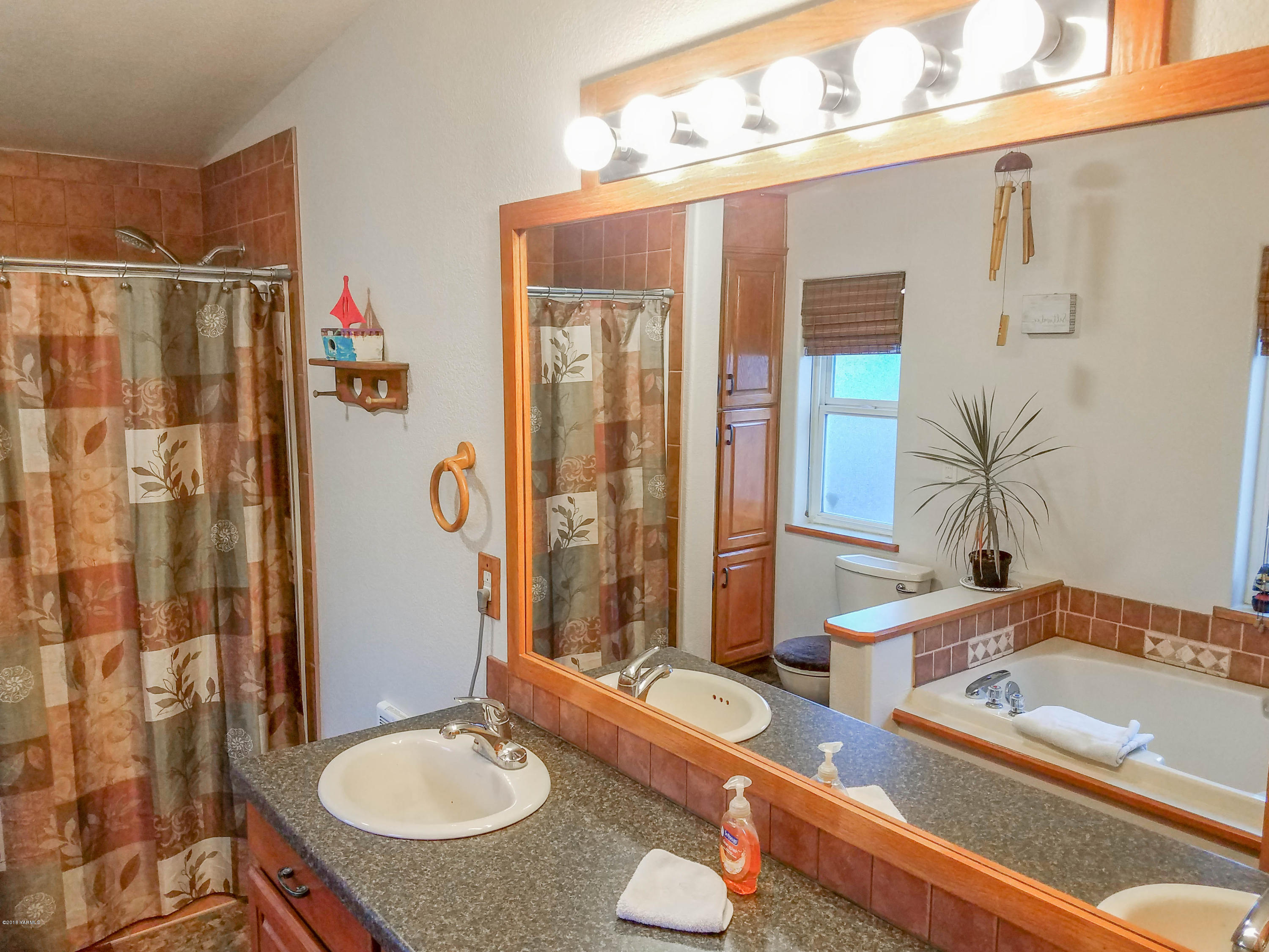 14811 Douglas Road Yakima, WA 98908 - Photo 11 of 18 a bathroom with a tub sink and mirror