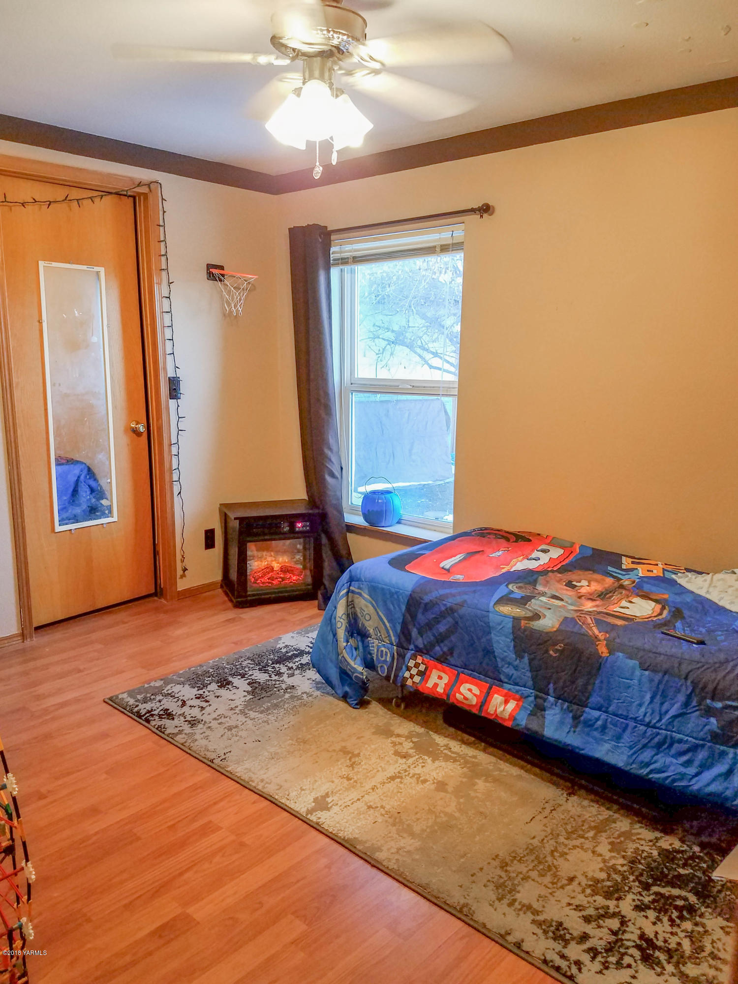 14811 Douglas Road Yakima, WA 98908 - Photo 12 of 18 a bedroom with a bed and a chandelier