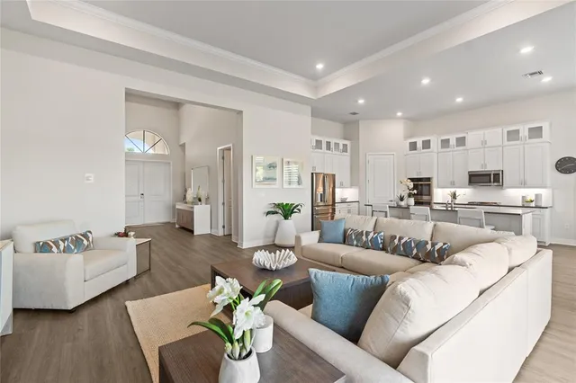 a living room with furniture and a view of kitchen