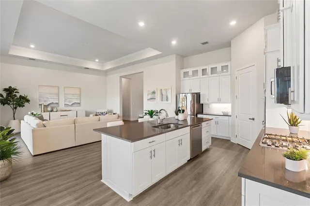 a kitchen with white cabinets and wooden floor
