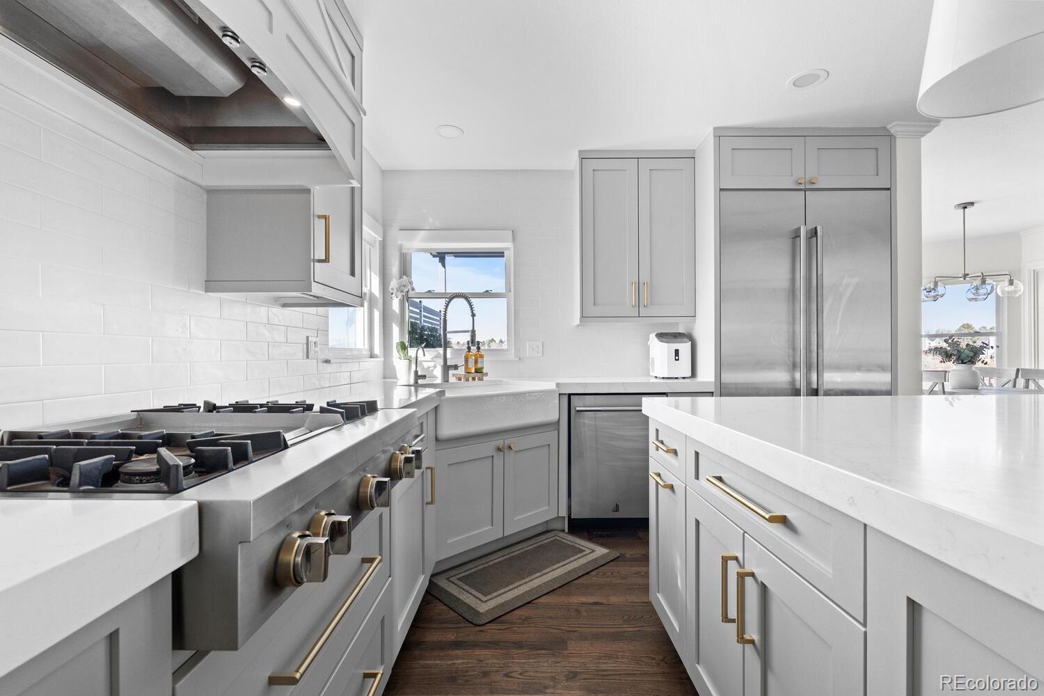 8855 South Wild Iris Run Highlands Ranch, CO 80126 - Photo 12 of 48 a kitchen with stainless steel appliances granite countertop a sink stove and cabinets