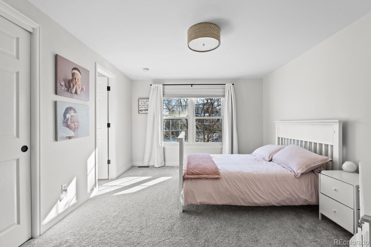 8855 South Wild Iris Run Highlands Ranch, CO 80126 - Photo 29 of 48 a bedroom with a large bed and a chandelier