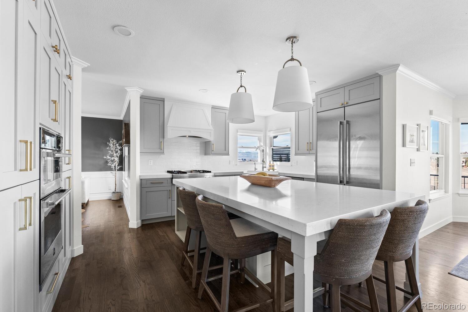 8855 South Wild Iris Run Highlands Ranch, CO 80126 - Photo 4 of 48 a kitchen with stainless steel appliances granite countertop a dining table chairs refrigerator and cabinets