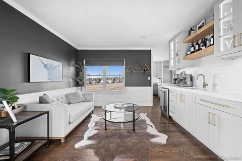 a living room with furniture a rug kitchen view and a window
