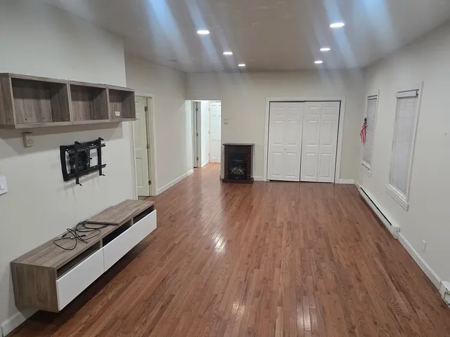 a view of an empty room with wooden floor
